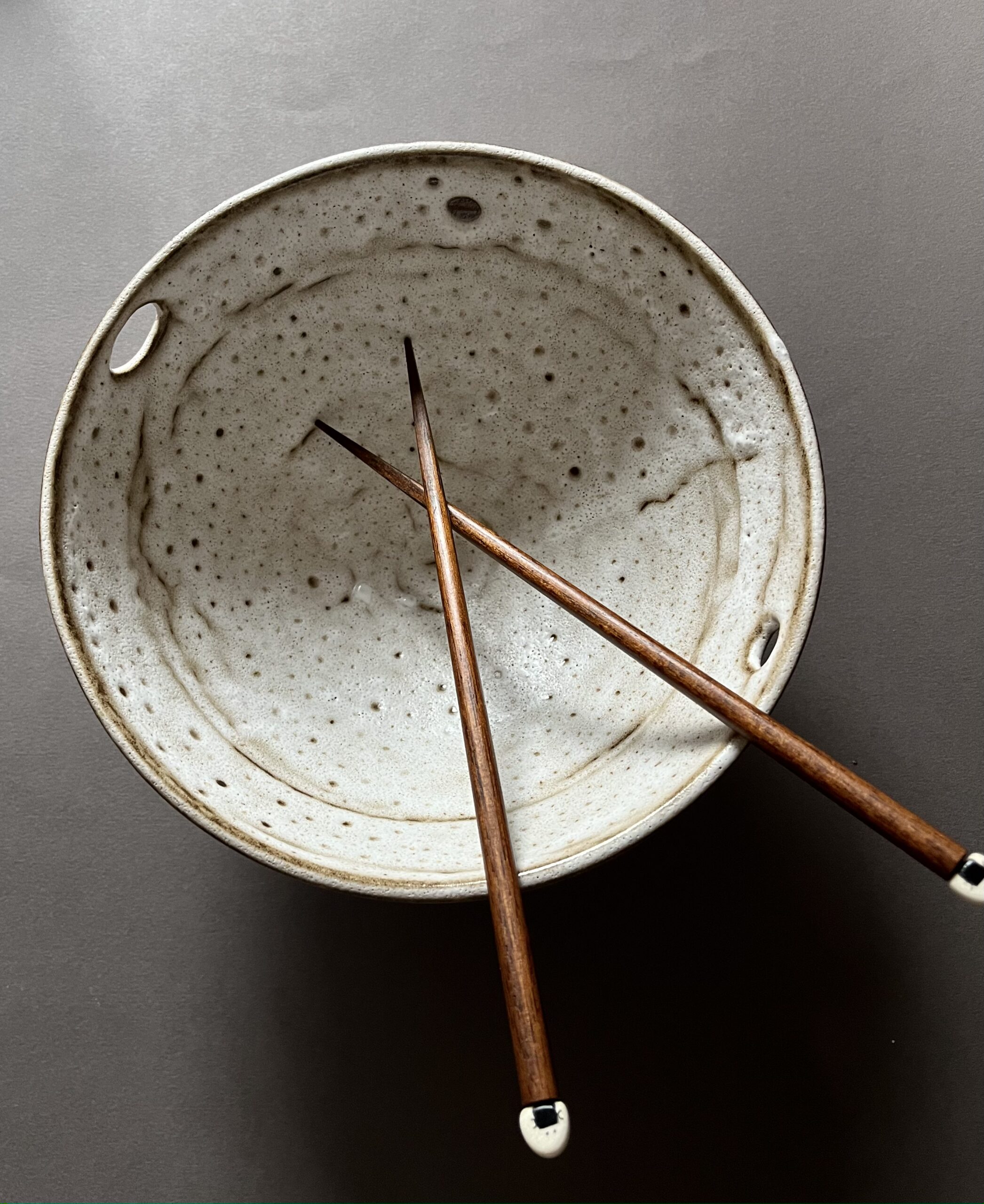 Bol à ramen Tommy vu de dessus, intérieur blanc velours moucheté et baguettes en bois croisées
