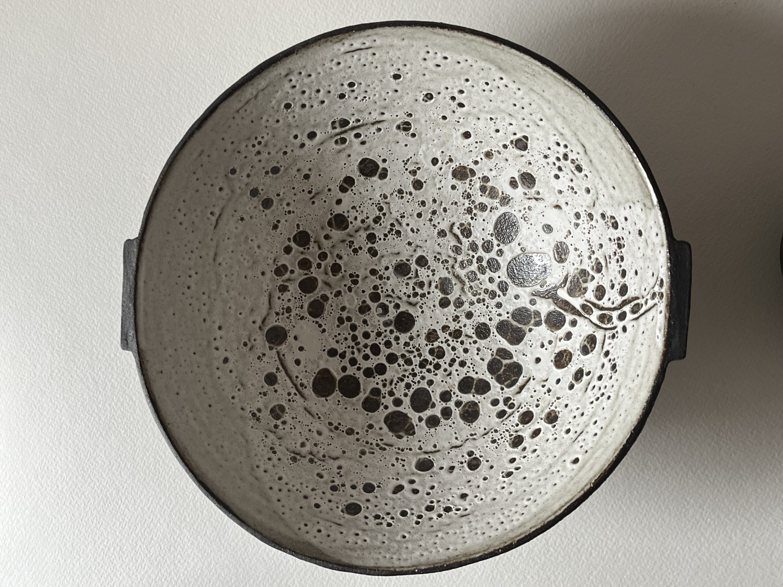 Coupe Rocaille évasée vue de dessus, intérieur blanc velours à pastilles noires, anses sur les côtés