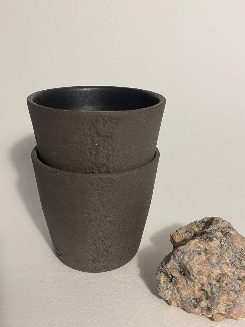 Deux gobelets Treb en grès brun brut empilés, intérieur noir mat, morceau de granit rose