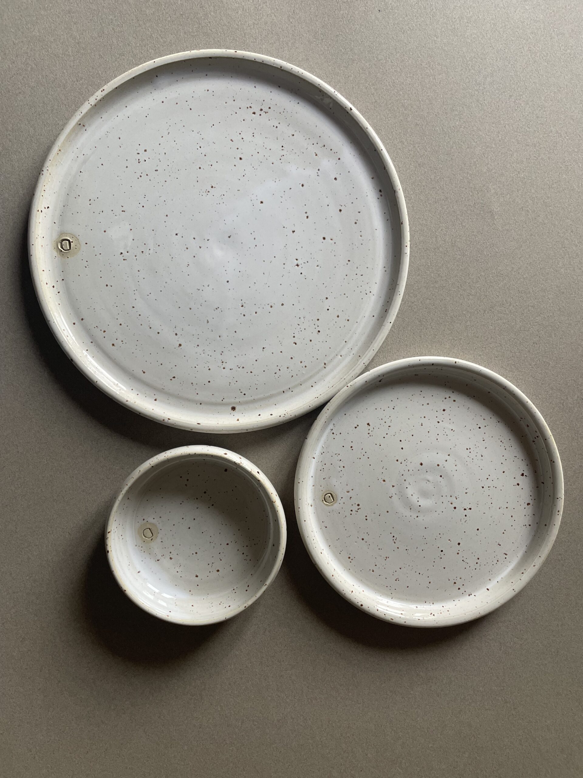 Grande assiette, petite assiette et ramequin Maya vus de dessus, émail blanc moucheté