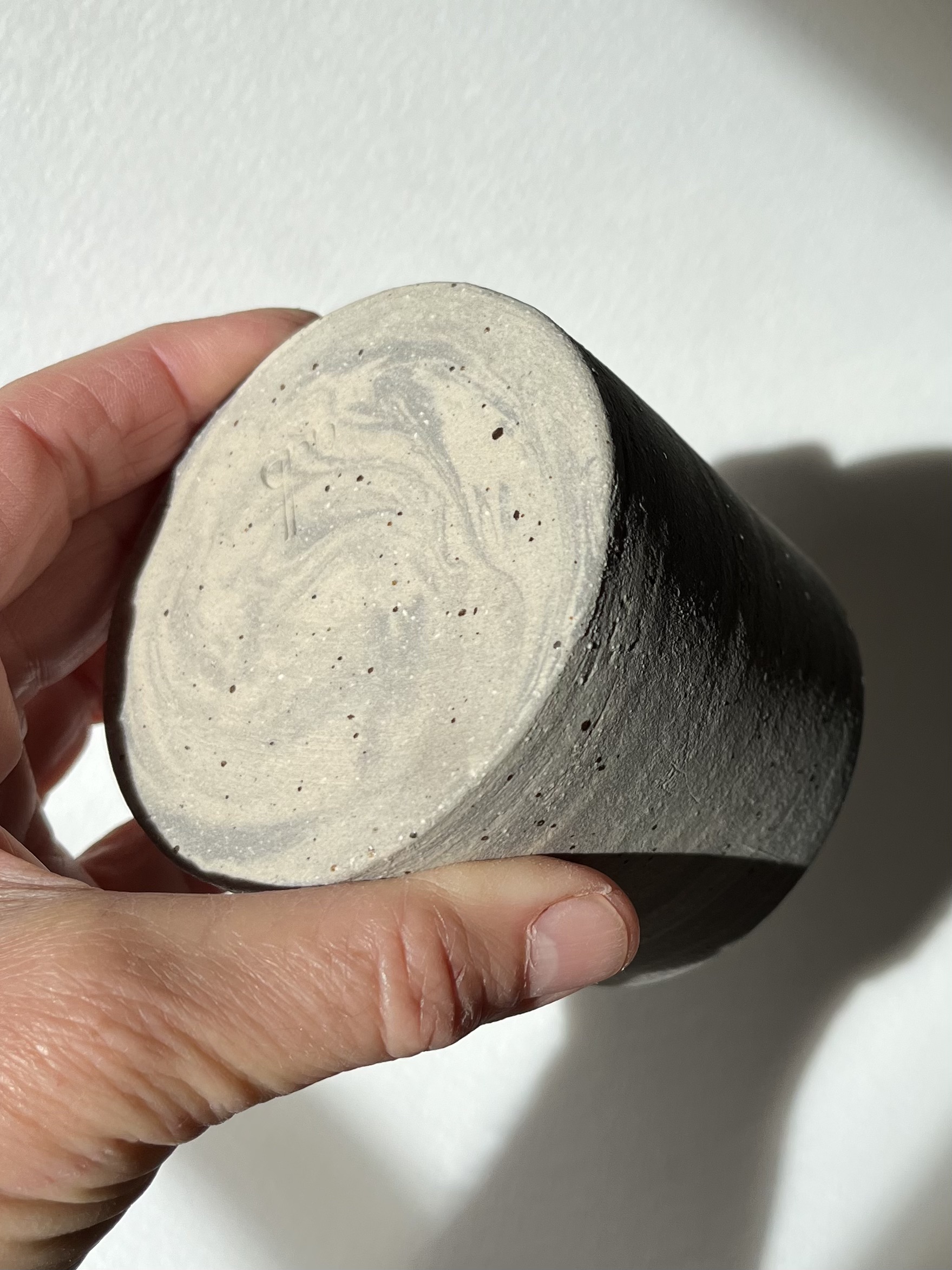 Gobelet Steph en grès gris marbré pyrité tenu en main, dessous brut aux veines grises