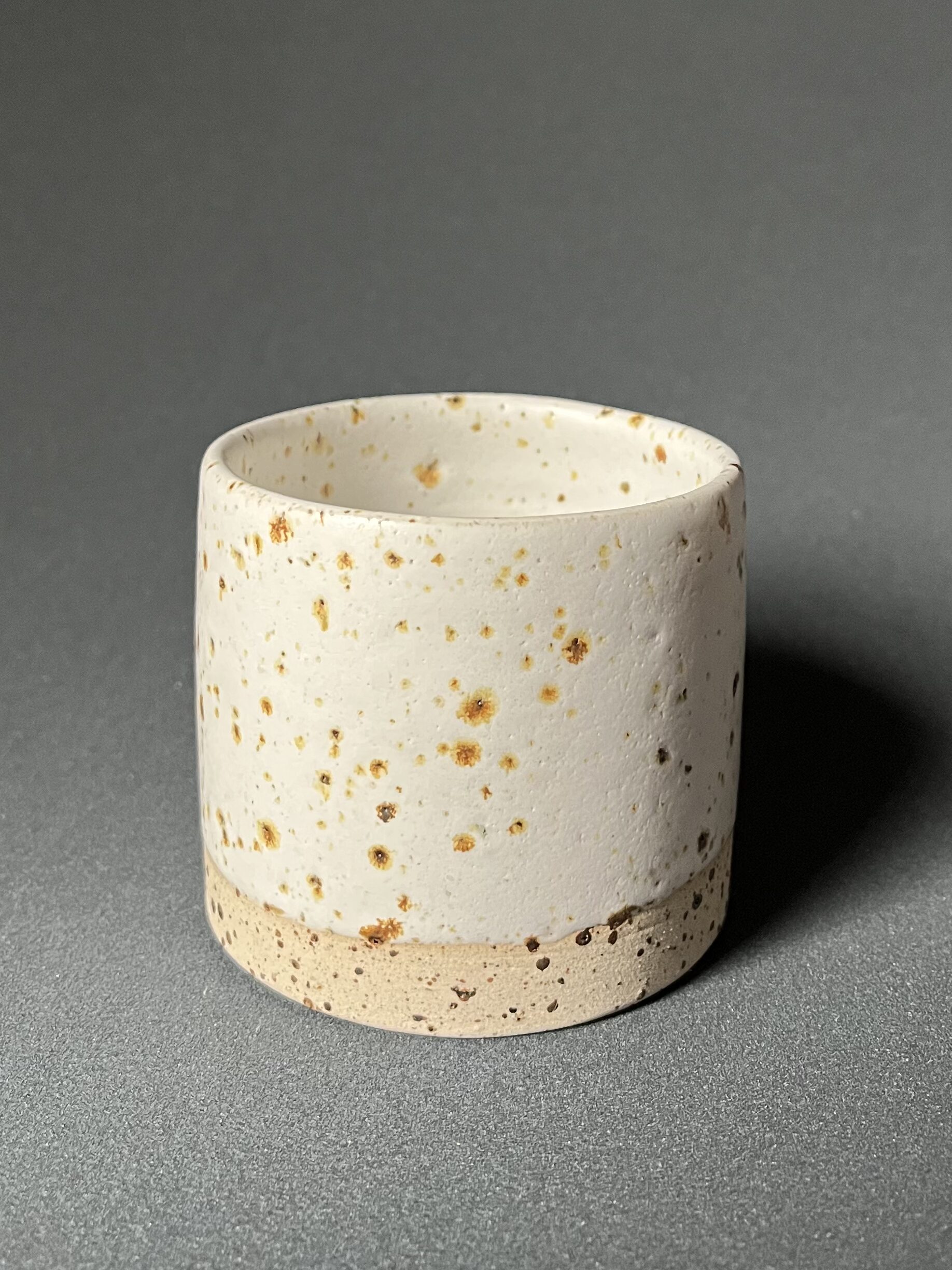Gobelet Steph en grès pyrité à l'émail blanc velours aux mouchetures dorées, vue de trois quarts