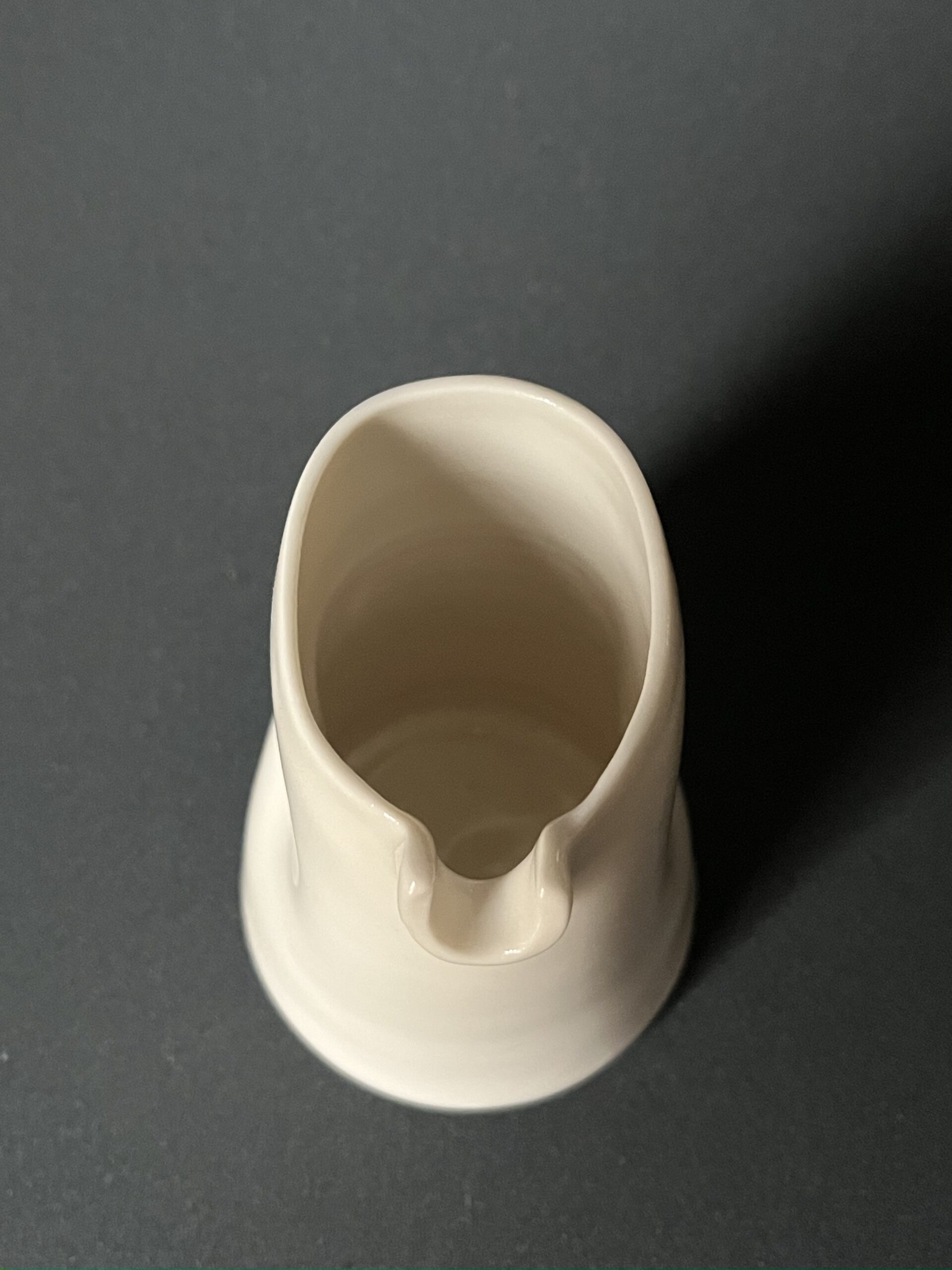 Saucière verseuse en porcelaine blanche vue de dessus, bec verseur et renfoncements pour la prise en main