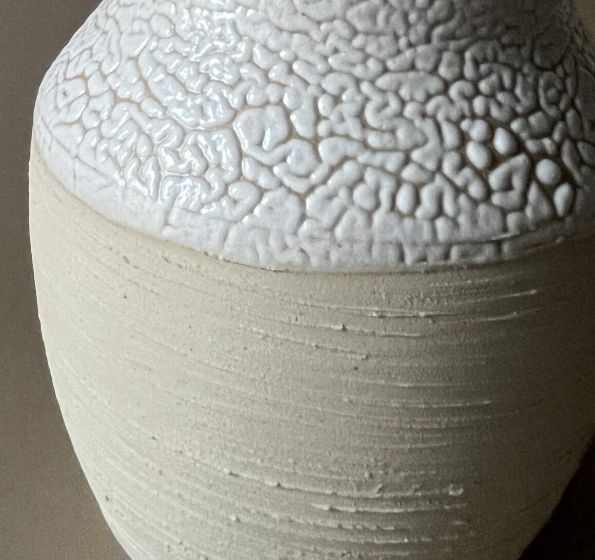 Vase Winter en grès beige strié à col large émaillé blanc rétracté, garni d'une graminée