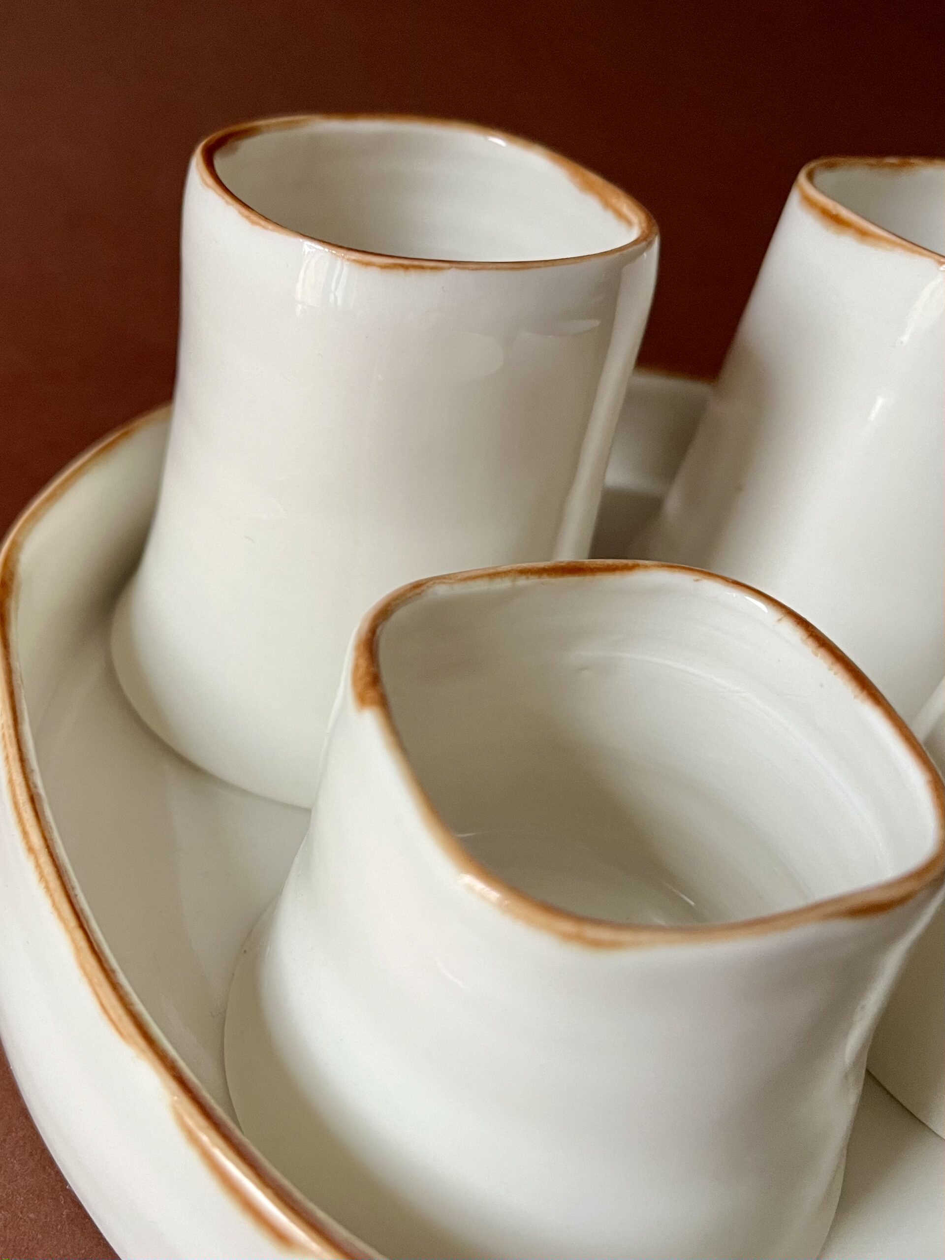 Tasses Ulysse lungo et expresso en porcelaine à liseré marron, gros plan sur leurs lèvres