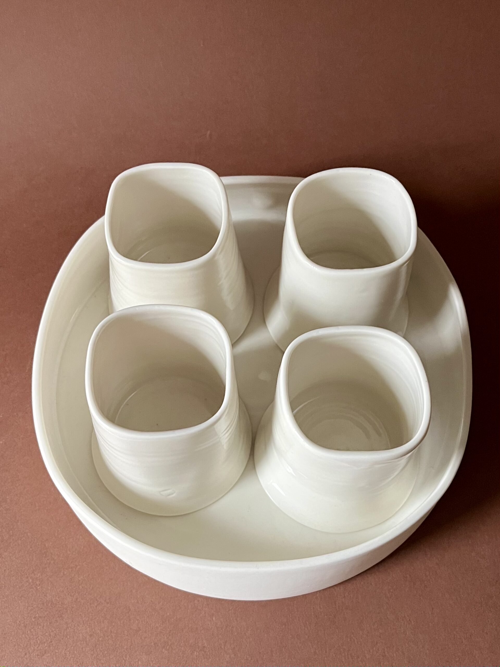 Set à café Ulysse blanc vu de dessus, quatre tasses carrées en porcelaine dans le plateau rond