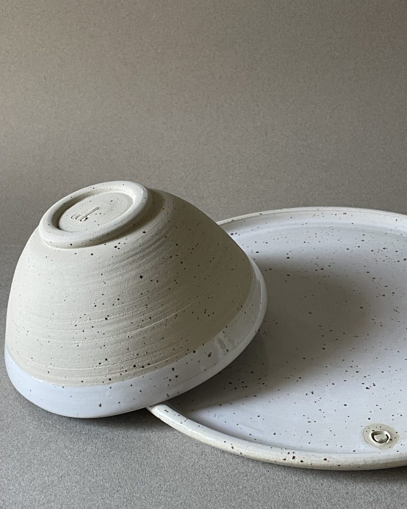 Bol Maya retourné montrant son pied en grès brut, posé sur une assiette plate Maya