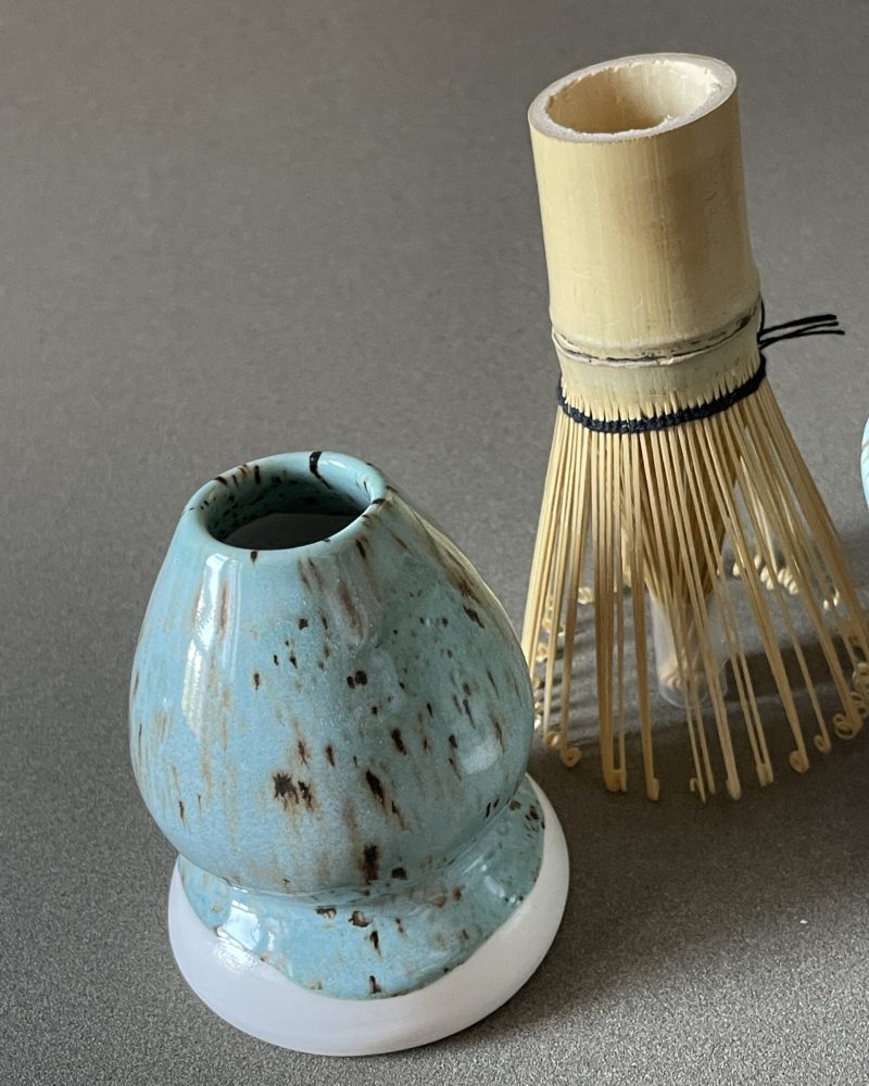 Repose-fouet à matcha Osaka en porcelaine céladon tacheté, avec fouet en bambou posé à côté
