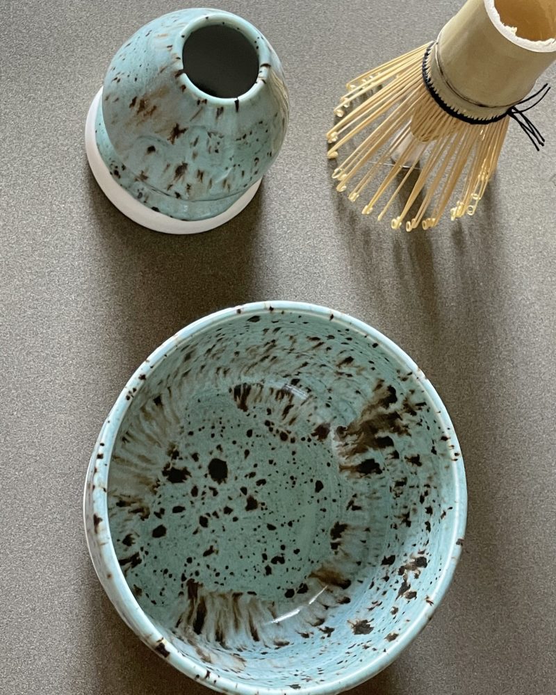 Bol à matcha Osaka vu de dessus, émail céladon tacheté, repose-fouet et fouet en bambou à côté