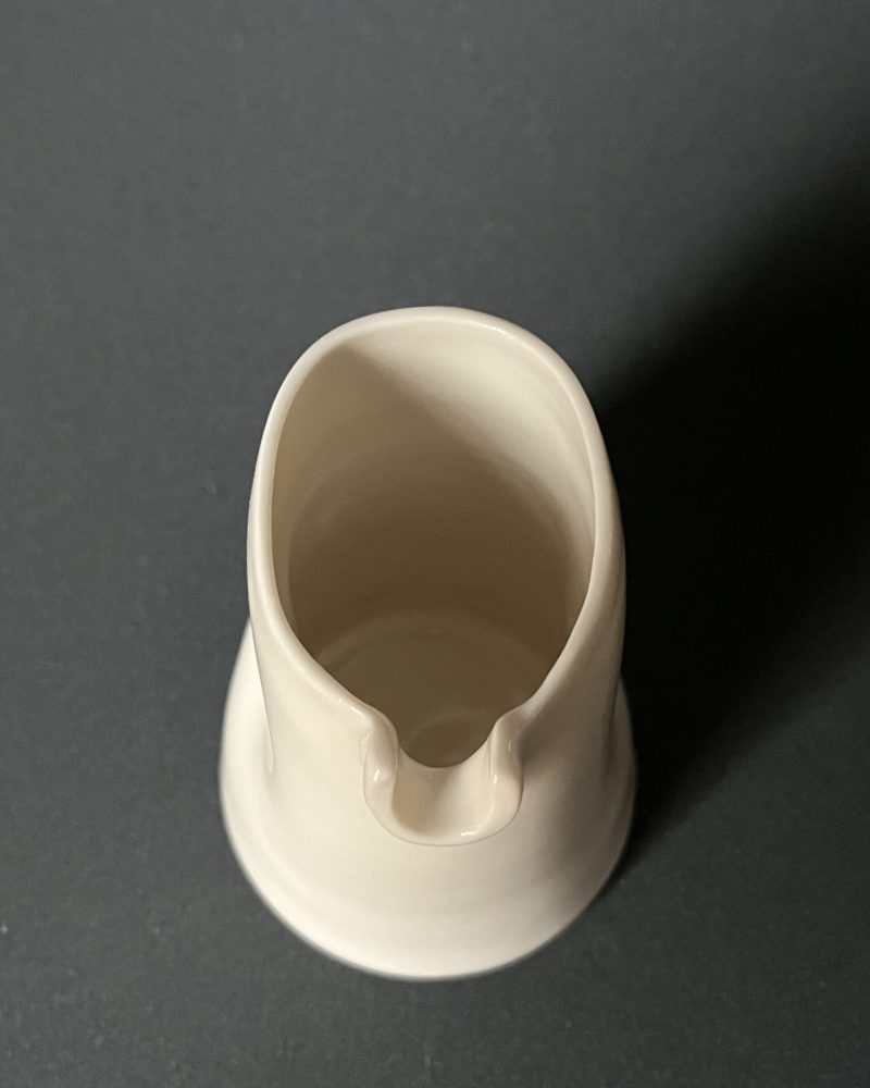 Saucière verseuse en porcelaine blanche vue de dessus, bec verseur et renfoncements pour la prise en main