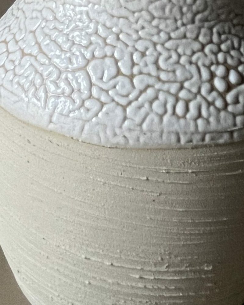 Vase Winter en grès beige strié à col large émaillé blanc rétracté, garni d'une graminée