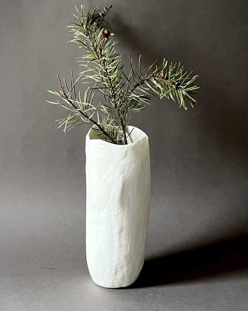 Photophore Éclosion cylindrique en porcelaine papier utilisé en vase avec une branche de pin