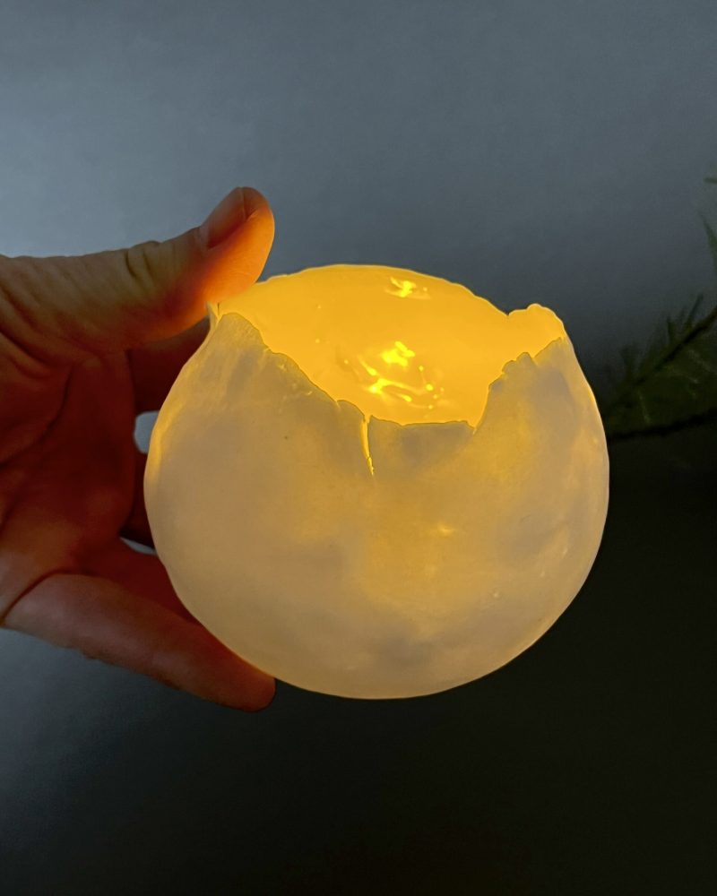 Photophore Éclosion allumé tenu en main, porcelaine papier translucide éclairée de l'intérieur