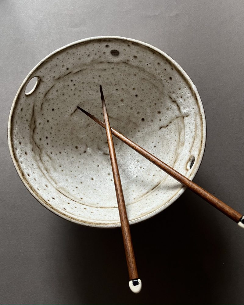 Bol à ramen Tommy vu de dessus, intérieur blanc velours moucheté et baguettes en bois croisées