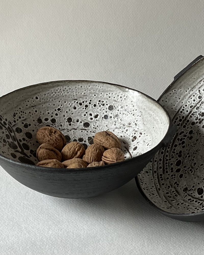 Deux coupes Rocaille en grès noir chamotté, intérieur émail blanc à pastilles, garnies de noix