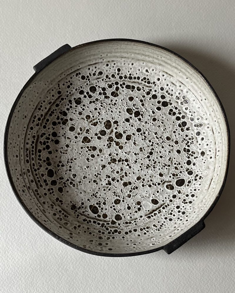 Coupe Rocaille plate vue de dessus, émail blanc velours à pastilles découvertes sur grès noir, deux petites anses