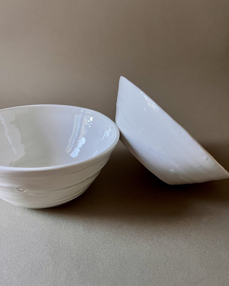 Deux bols Purete en porcelaine blanche, l'un en équilibre sur le bord de l'autre