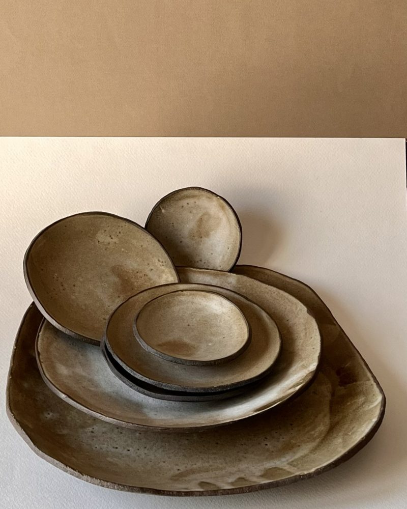 Pile d'assiettes et coupelles en grès brun foncé à l'émail beige nuageux, formes libres
