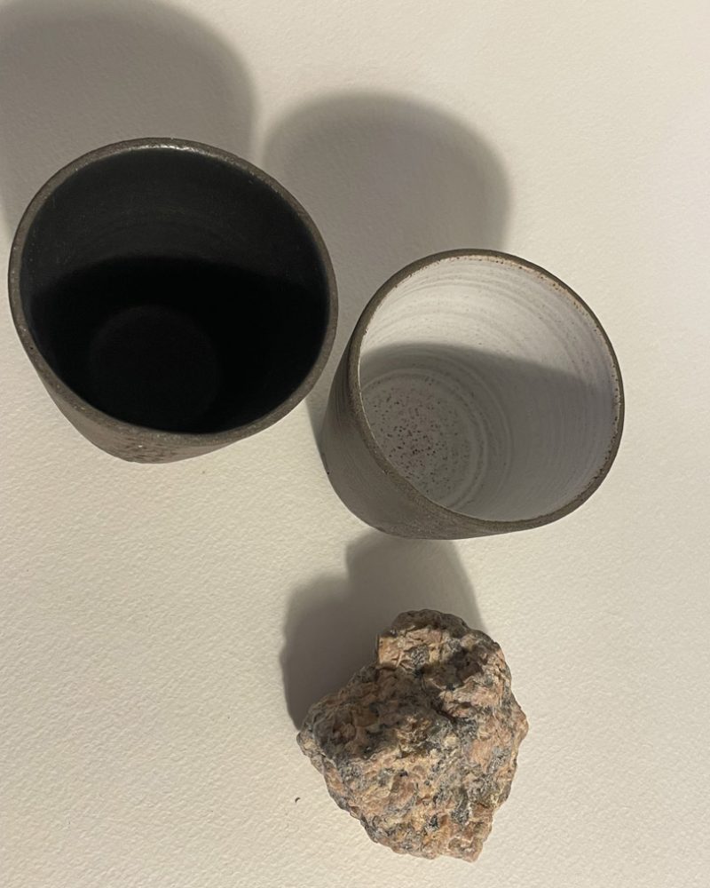 Gobelets Treb vus de dessus, émail noir et blanc Deux gobelets Treb vus de dessus, intérieurs émaillés noir mat et blanc mat, granit rose à côté