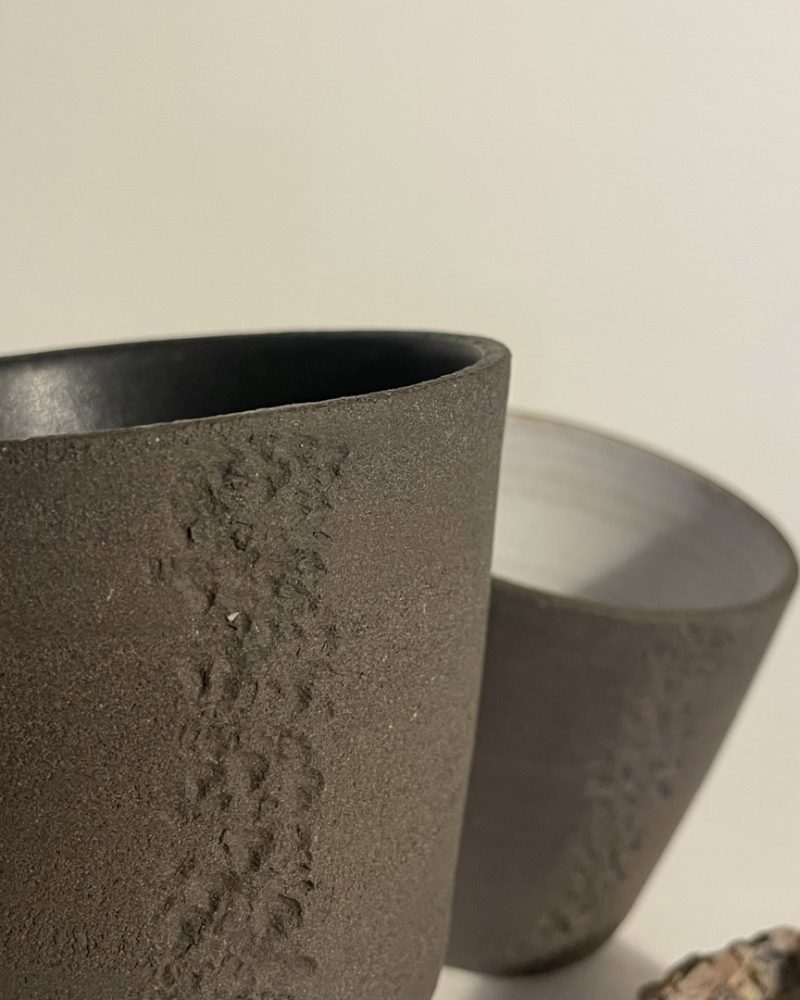 Gobelet Treb, empreinte de granit en gros plan Gros plan sur l'empreinte de granit rose imprimée dans la terre brute d'un gobelet Treb