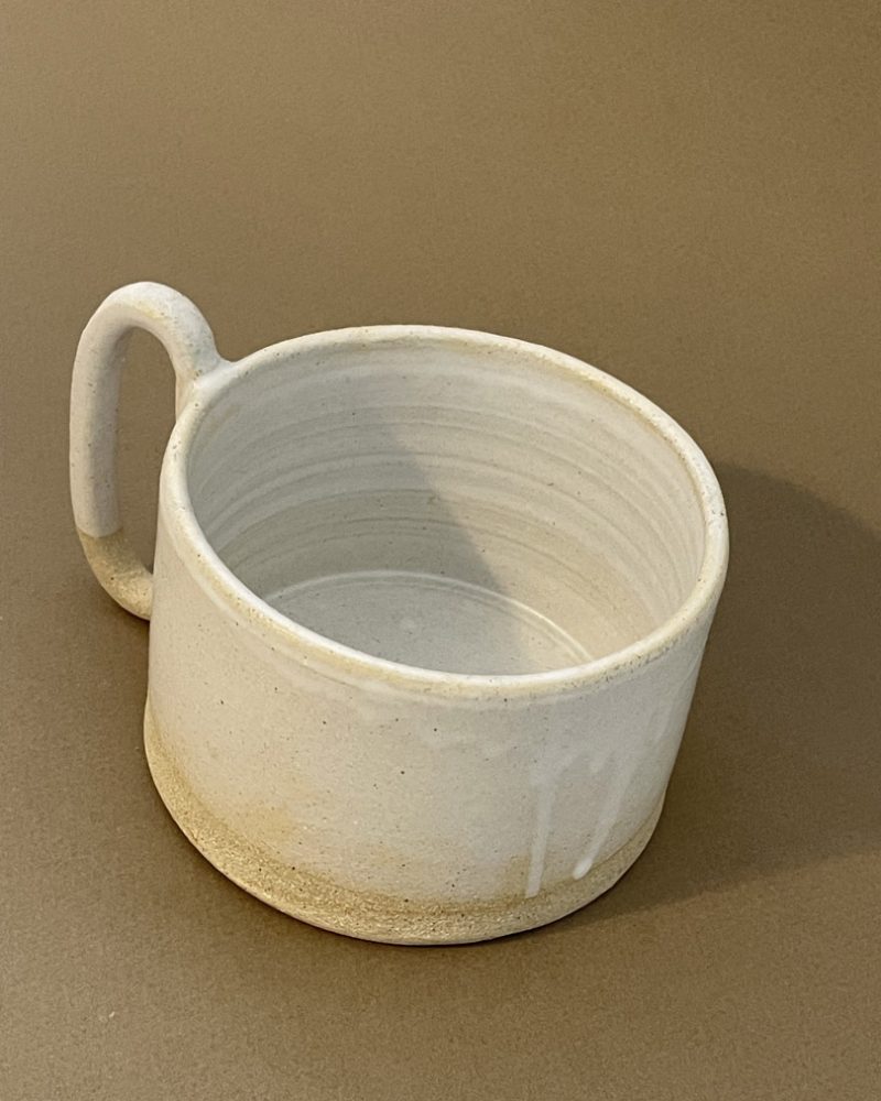 Tasse à thé Caro en grès chamotté émaillé blanc mat, vue de trois quarts, base brute